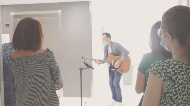 Le chanteur pierre Henri en guitare face aux patients et au personnel soignant.